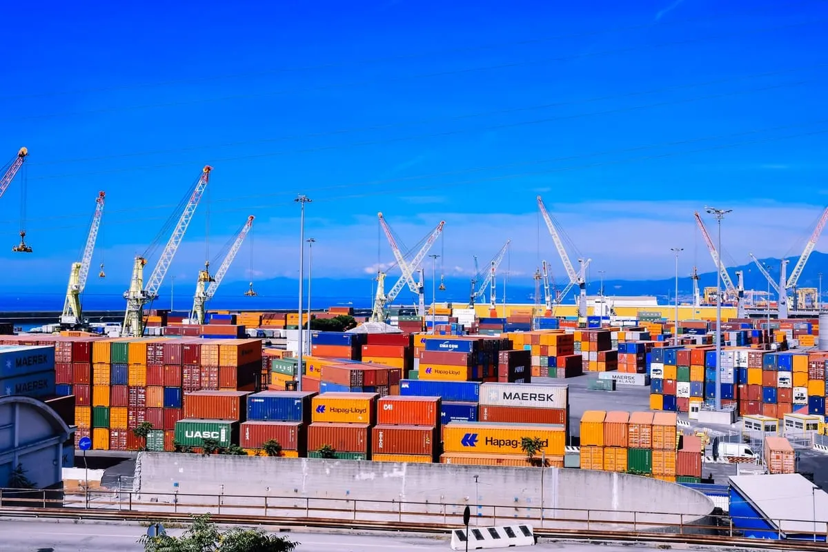 Puerto de contenedores con grúas cargando mercancía de importación